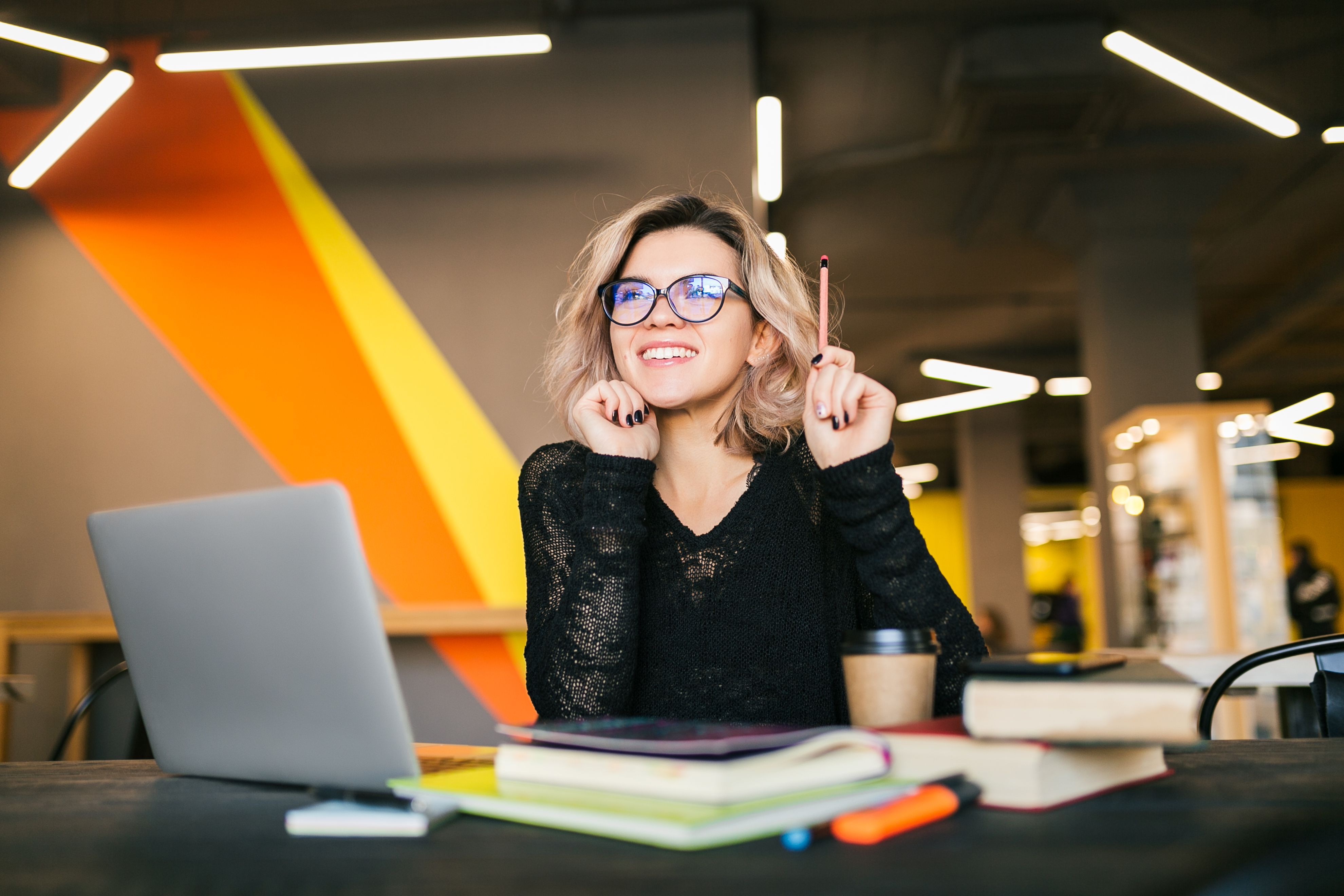 portrait-young-pretty-woman-sitting-table-black-shirt-working-laptop-co-working-office